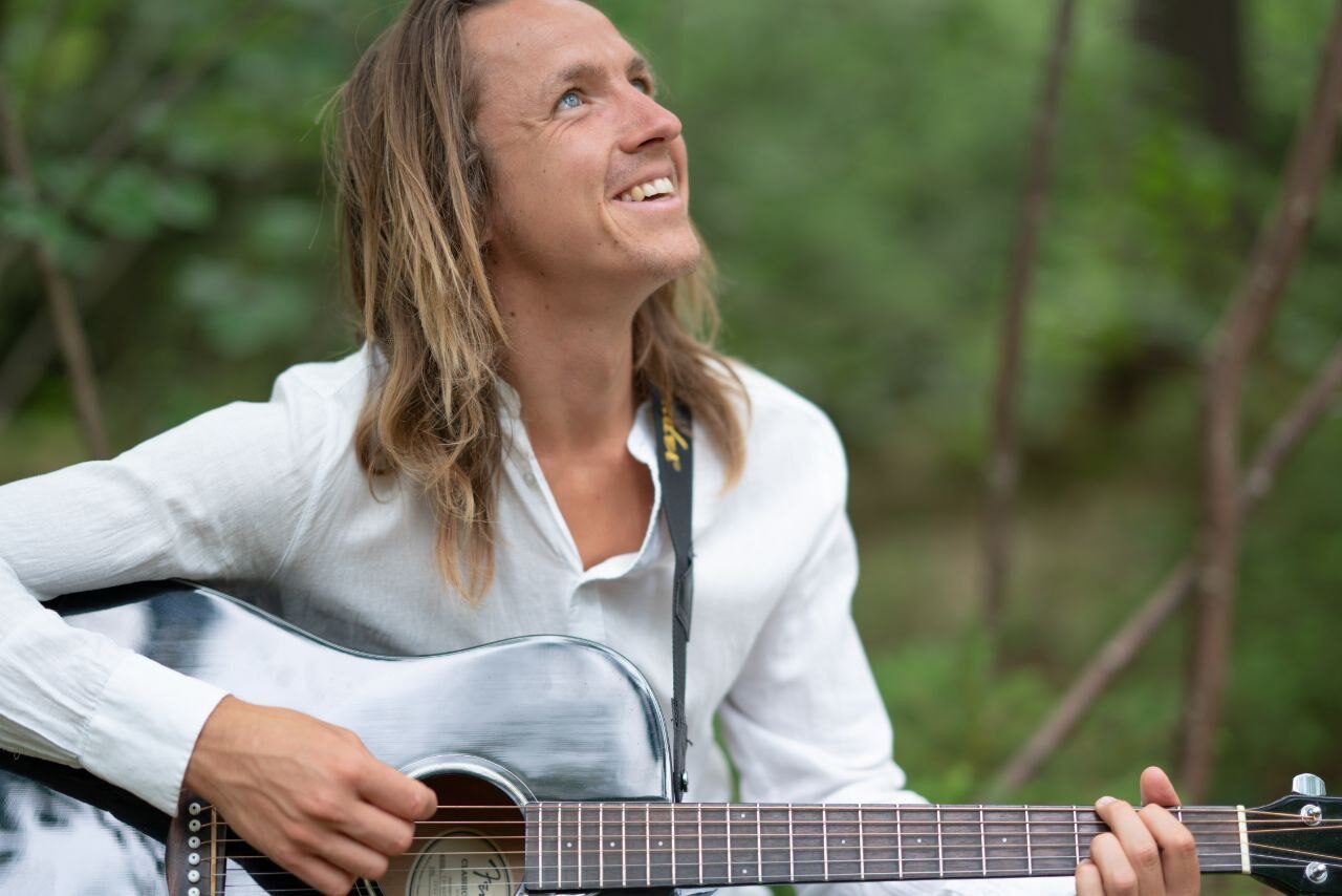 Philipp Richter mit Gitarre im Wald