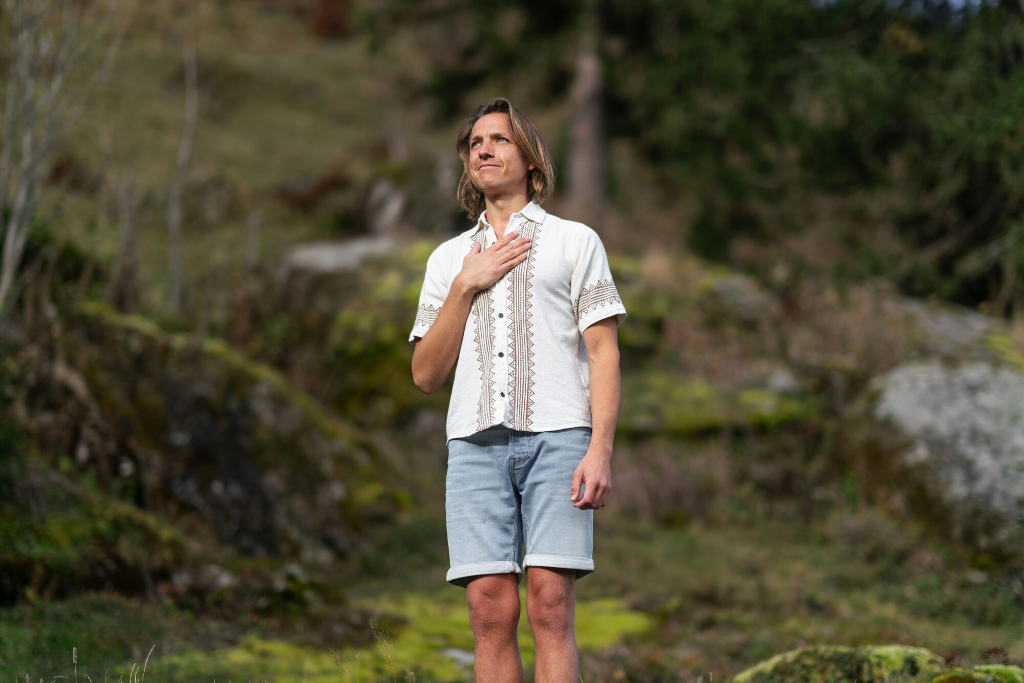 Philipp Richter mit der Hand am Herzen in der Natur