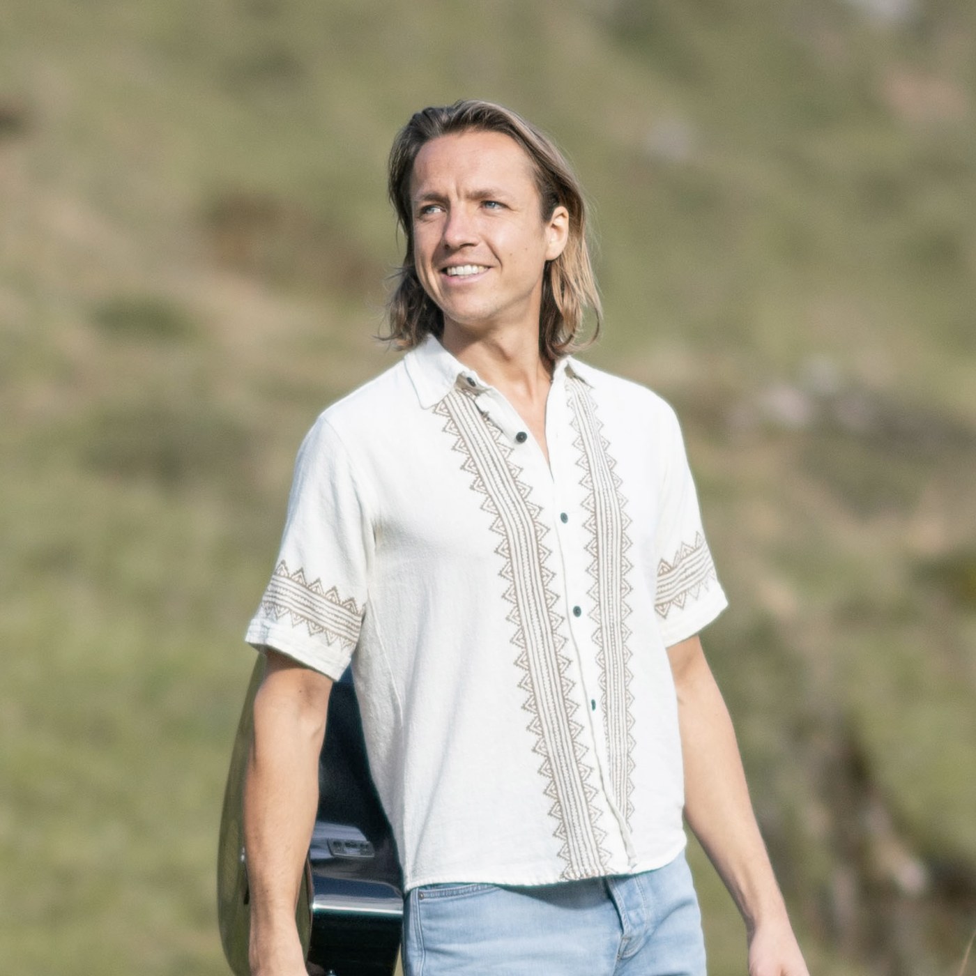 Musiker mit Gitarre in der Natur